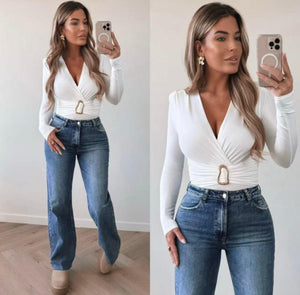 Model wears White Dressy Bodysuit with long sleeves and flattering wrap front .Bodysuit has a flattering shape enhancing gathered waist with gold clasp detailing and is a stretchy fabric